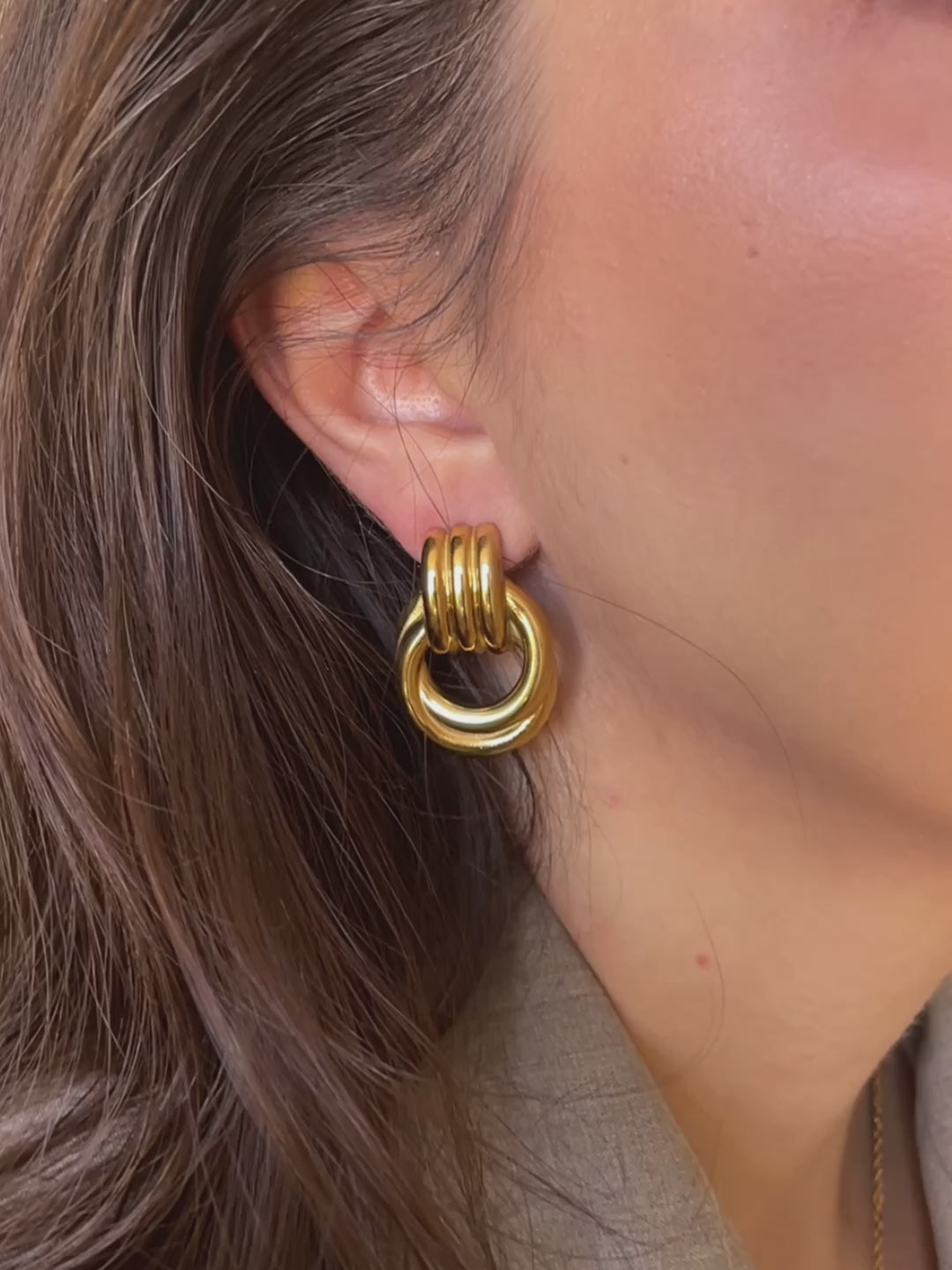 ideo of woman wearing gold Amara Knot Earrings, showing movement and shine, large vintage-inspired statement earrings for women